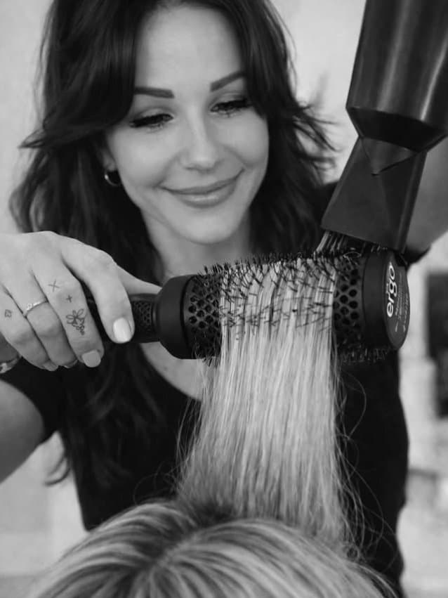 Heni finishing a blow-dry — Hair by Heni, Tampa.